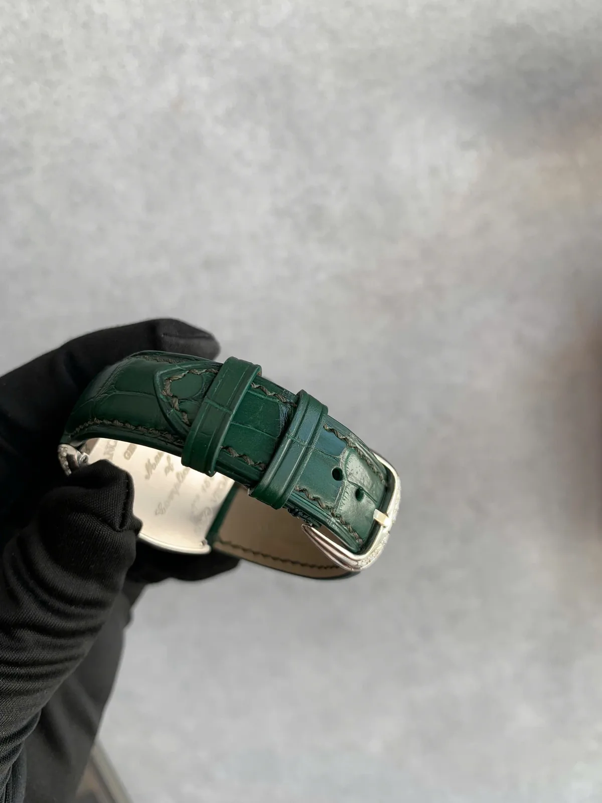 Mặt lót màu be, khóa gài và hai vòng giữ dây của dây da cá sấu đồng hồ Franck Muller